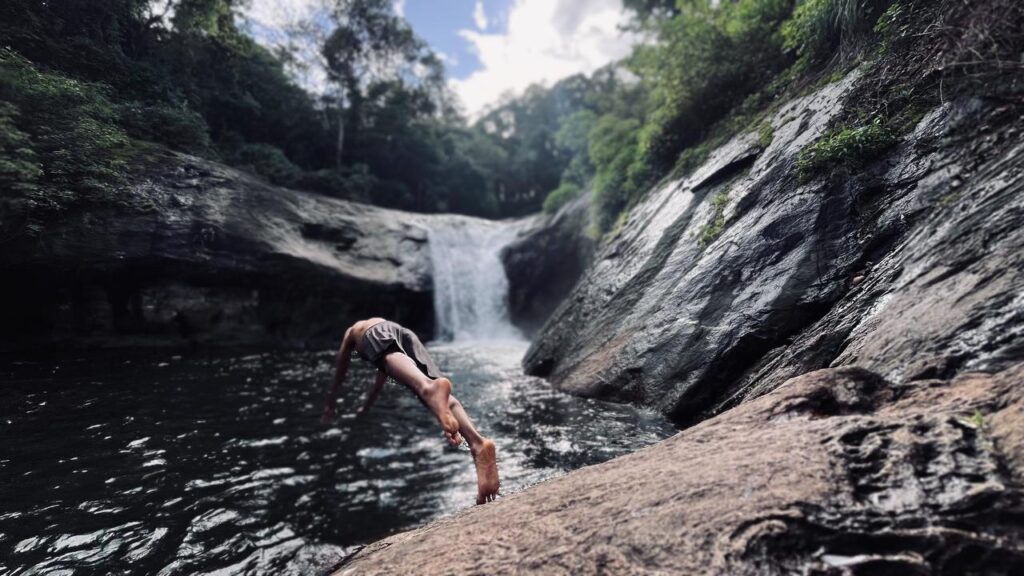 best travel photographer in wayand a man jumbed a small river
